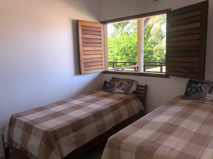 Quarto 2 camas: solteirão de madeira e cama box de solteiro, com janela e ar condicionado