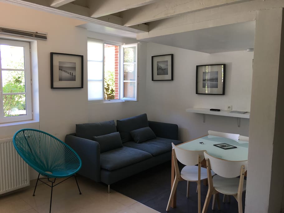 Salon-salle à manger. Un canapé 3 personnes plus un fauteuil (très confortable !) accompagné d'une table à rallonge et de 5 chaises pour s'attabler.