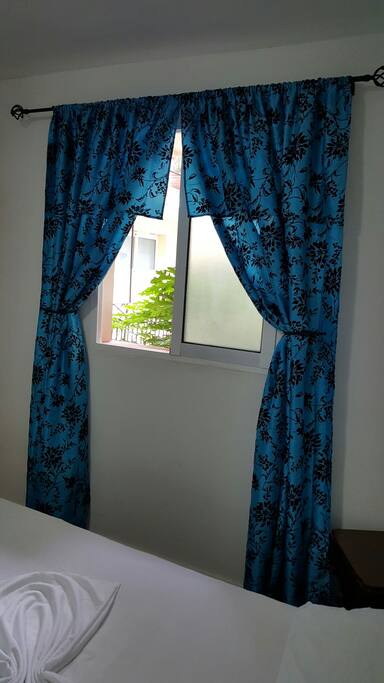 Ventana de la habitación con vista hacia el jardín interior del complejo.