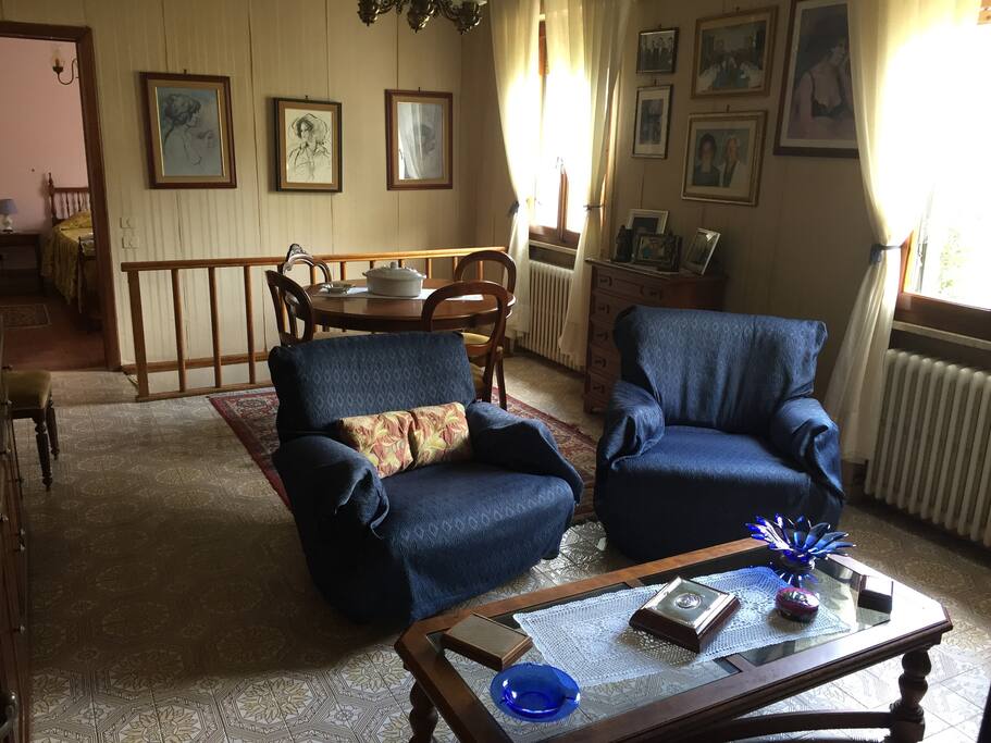 Ampio salotto (da cui si accede alla taverna) con 2 poltrone, tavolo e televisione.