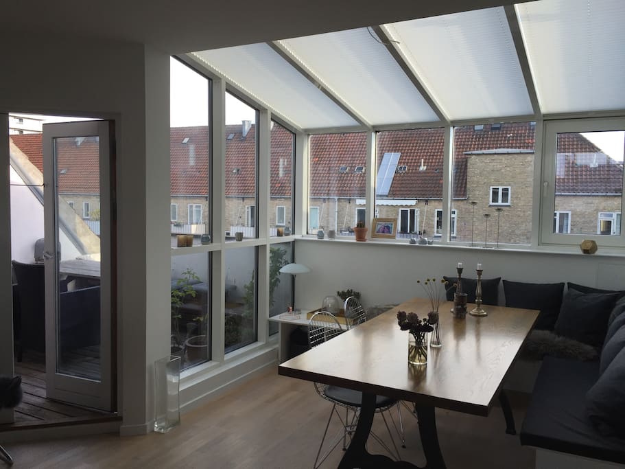 Dining corner in open connection with living room and kitchen and with a view to the balcony