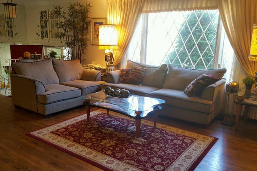Living room has a sectional sofa and lots of natural light