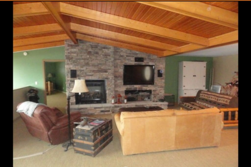 Family room features vaulted ceilings with beautiful stone and wood work.