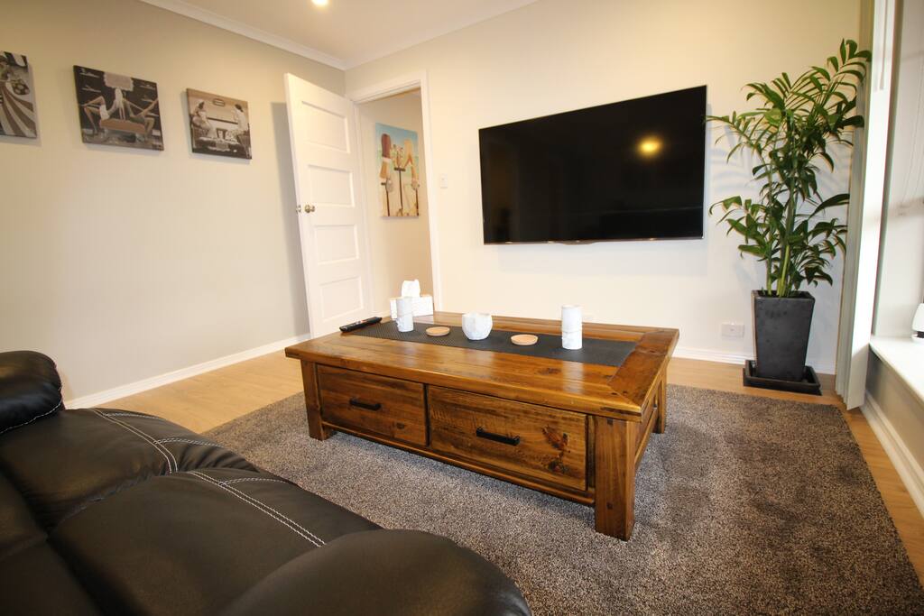 relax infront of the 64" LED TV in the faux leather recliner couch.