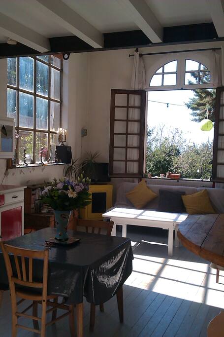 salon salle à manger avec fenêtre donnant sur la terrasse vue sur mer.