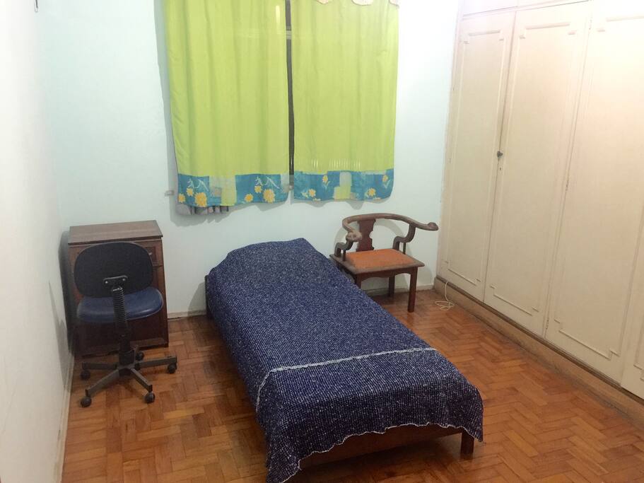 Um dos três quartos, cama de solteiro, guarda roupas, ventilador de teto e televisão.
