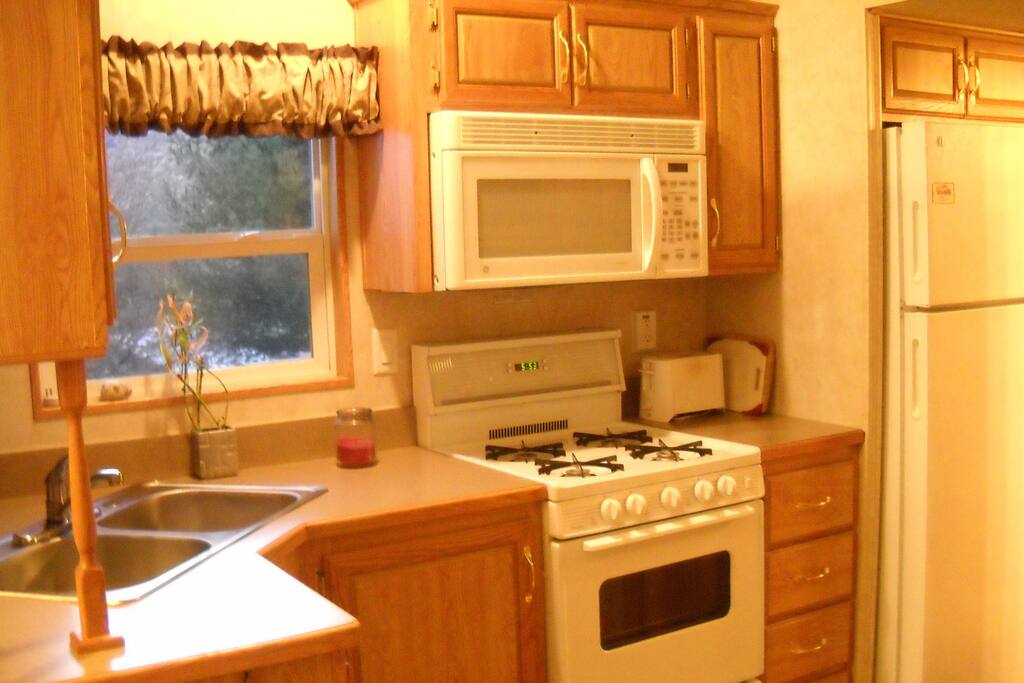 Kitchen with four burner gas stove, oven, microwave, toaster, coffee maker