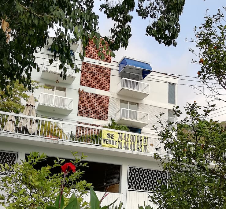 Vista externa del edificio, es el del toldo azul arriba con estacionamientos abajo
