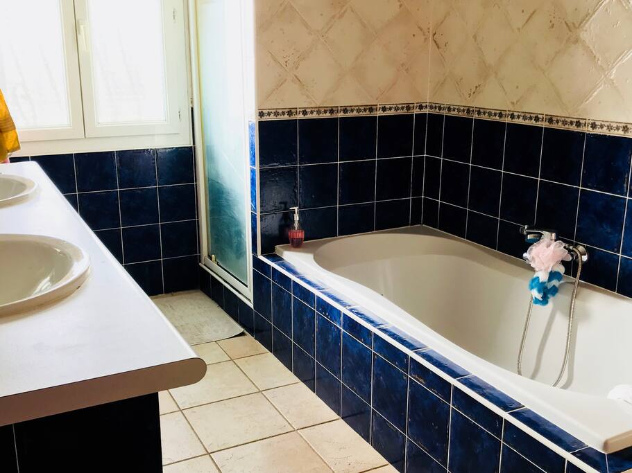 Salle de bain avec baignoire, douche et deux éviers