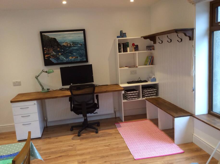 Studio area with bookshelves and shoe cubicles and coat hungers.