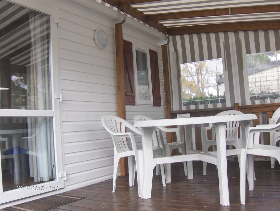 terrasse de 15m2 semi couverte avec table et chaises, 2 chaises longues