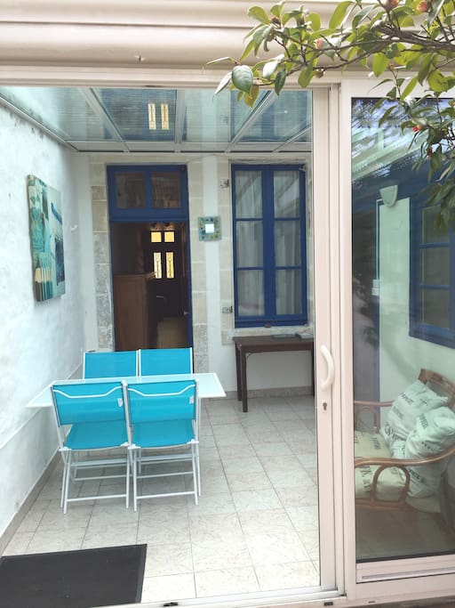 Véranda, couloir (qui dessert la 1ère et la 2ème chambres) et au fond la porte d'entrée