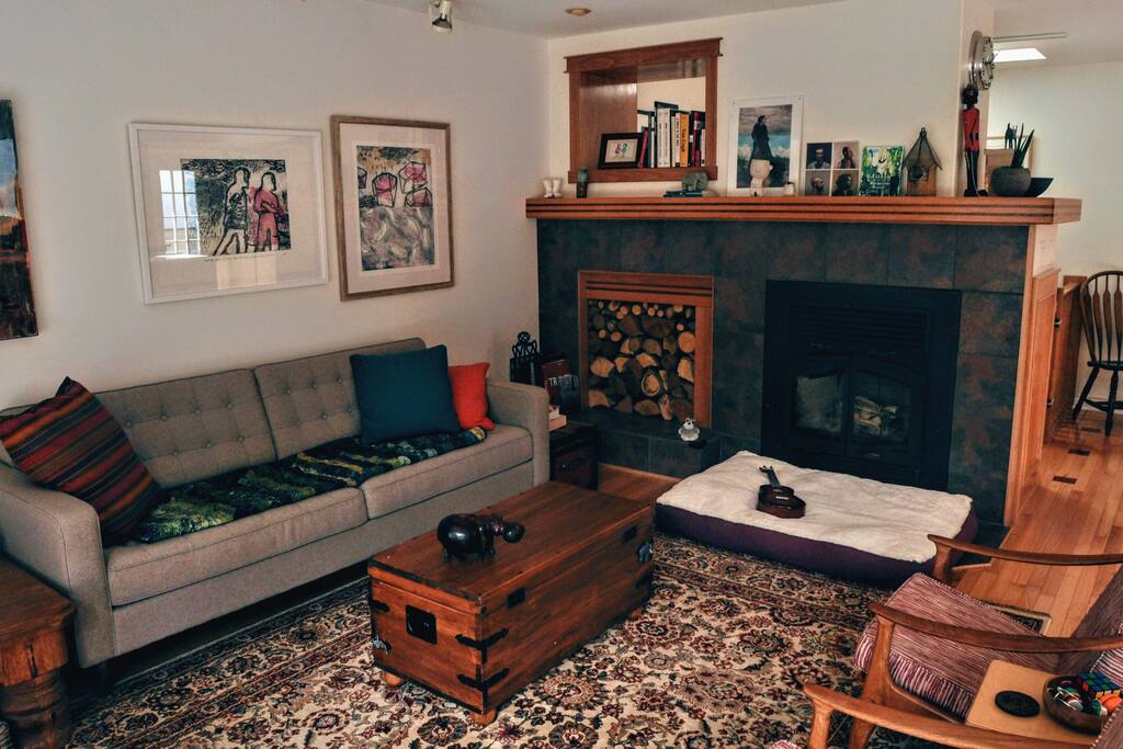 Main sitting area, with wood-burning fireplace, record player, and a beautiful wall of windows with stunning views. (3/3)