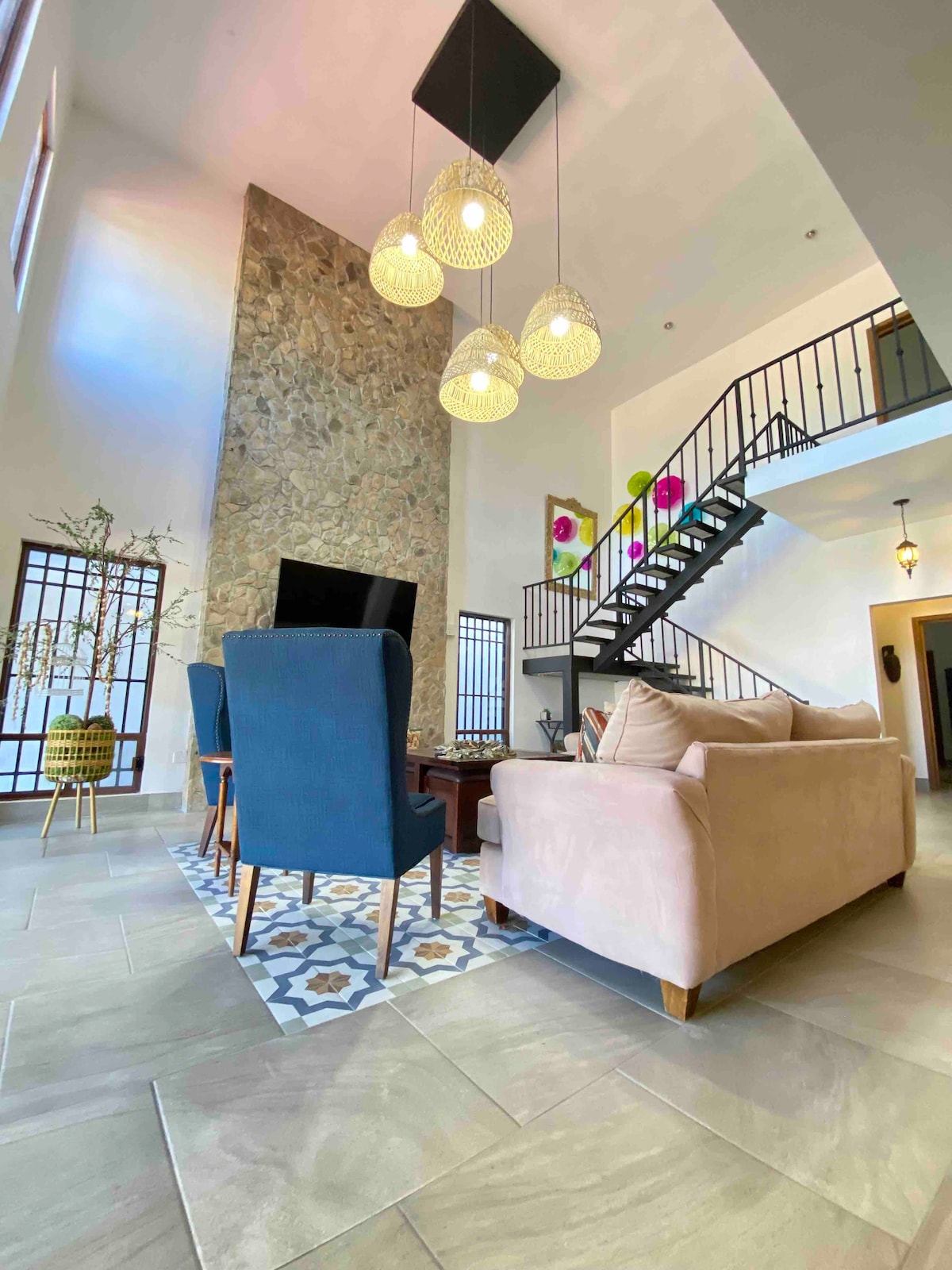 Dhoma jonë e ndenjjes me dy lartësi me televizor do të jetë qendra e mbledhjeve të tua.  
Kandili i tij spektakolar kujdeset për gjithë vëmendjen!