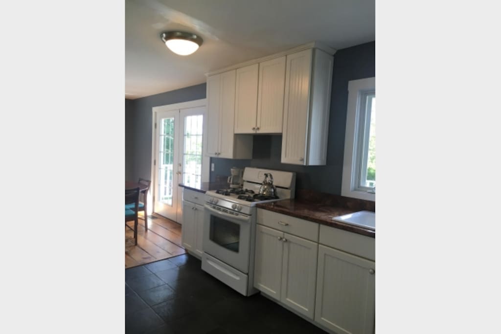 Newer kitchen with marble countertops and full sized fridge to the left out of this frame.