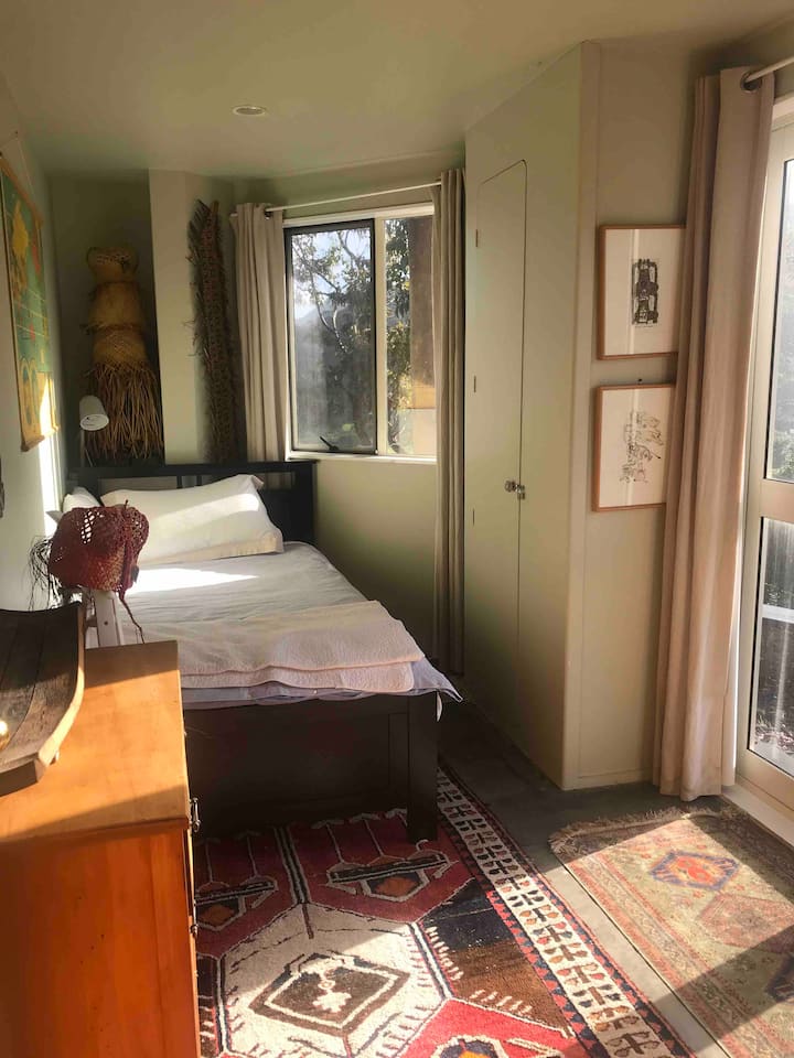 Chumba cha mtu mmoja kilicho na milango inayofunguliwa nje .