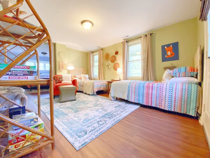 The downstairs main room includes two twin beds, chair and a smart TV. There is a curtain that separates this area from the other  bedroom. A full bath with a claw foot tub/shower is also included in the downstairs.