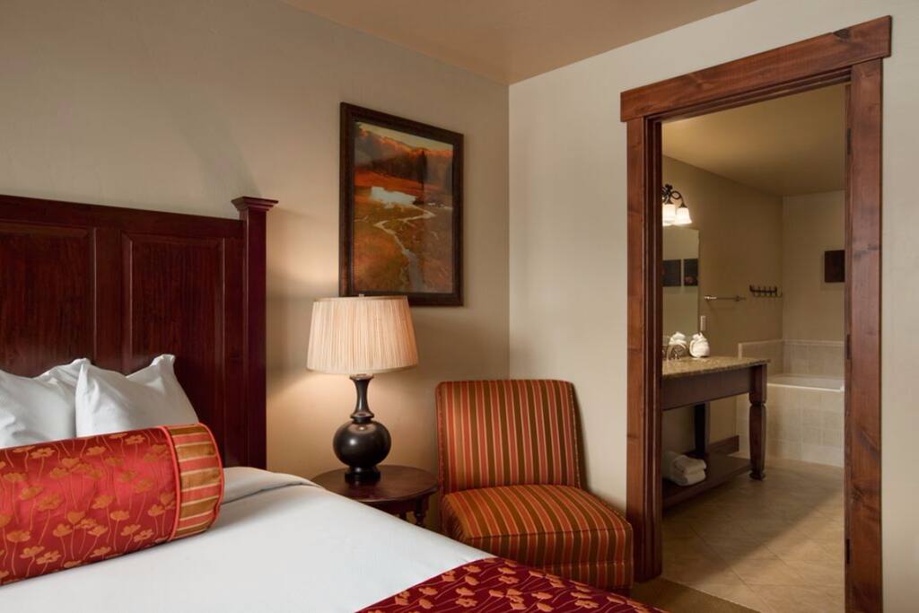 The Master Bathroom includes a shower, as well as a large bathtub with added jets, and a doubles sink leading to the Master Bedroom, with a king bed and TV.