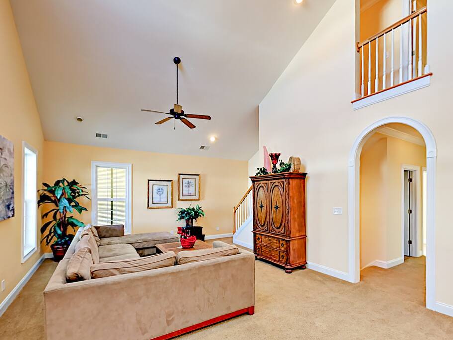 Relax in the first-floor living room, which holds a large sectional sofa and a flat screen TV.