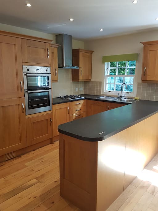 Large dining kitchen with oven, grill, hob, dishwasher, fridge freezer, washing machine and tumble dryer.