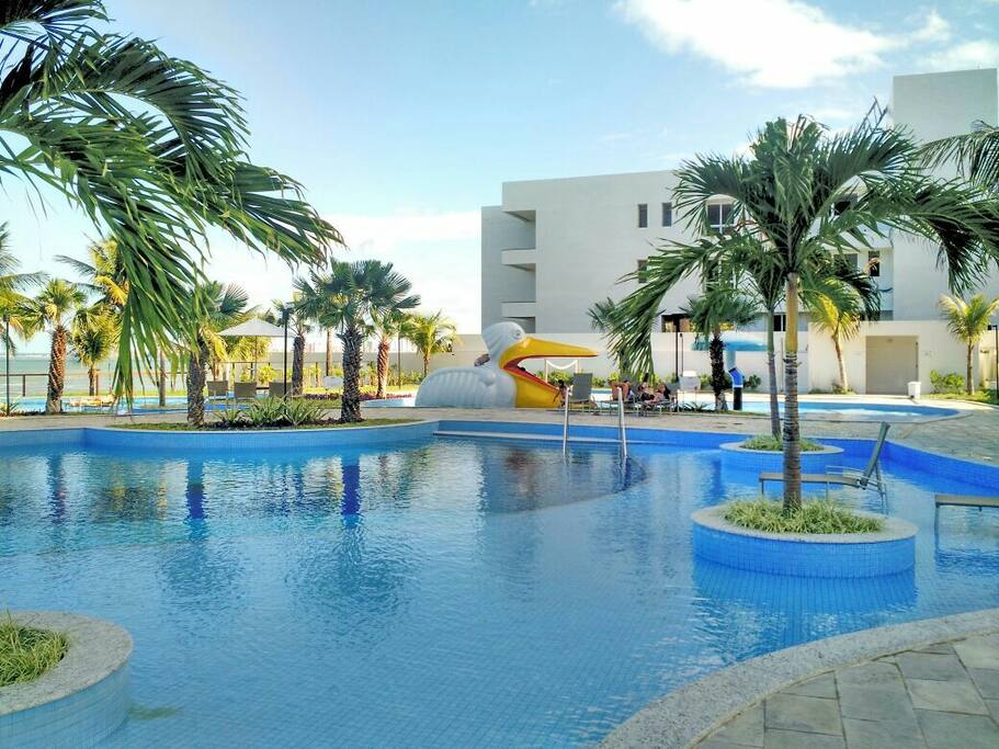 Área de piscina com o mar mais a frente.