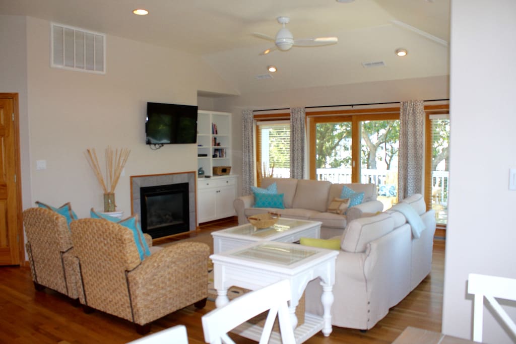 Living room with sliders to upper-level deck, fireplace, hardwood floors and smart TV! Lots of books and games.
