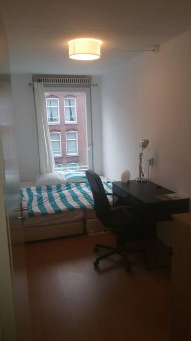 The cozy bedroom for two includes a desk and a chair