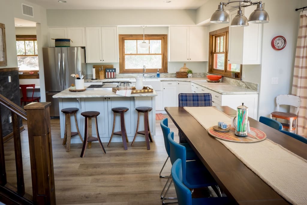 Eight chairs at the table, plus four stools at counter, plus two tables outside on the porch