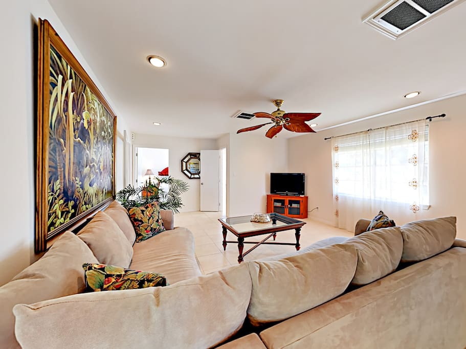 Bright and airy living room with tile floors and a 40" flat screen TV.