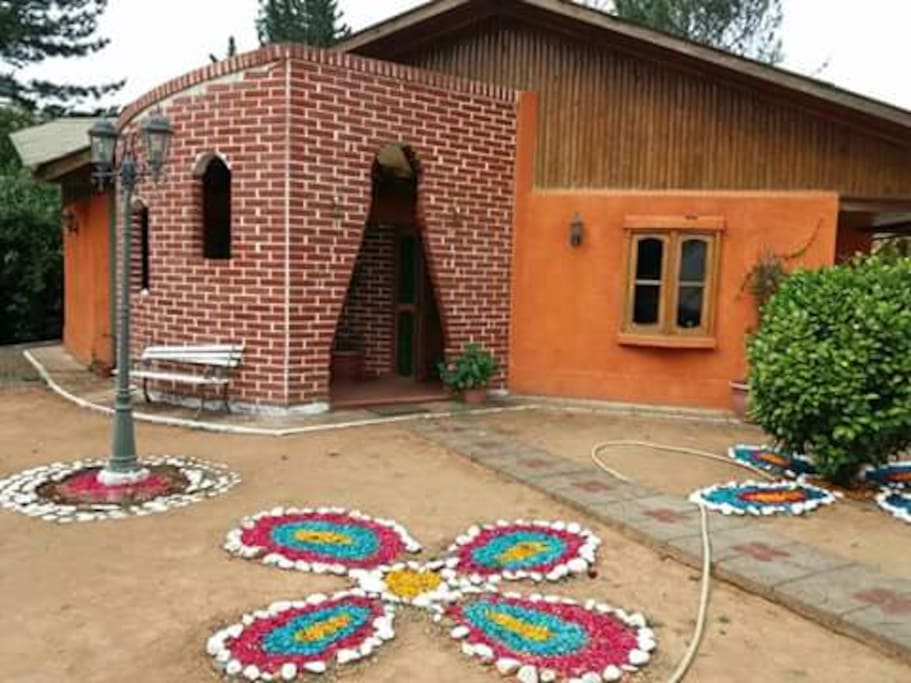 Entrada principal a la casa.
Frente a jardines con plazoleta y escaños de descanso