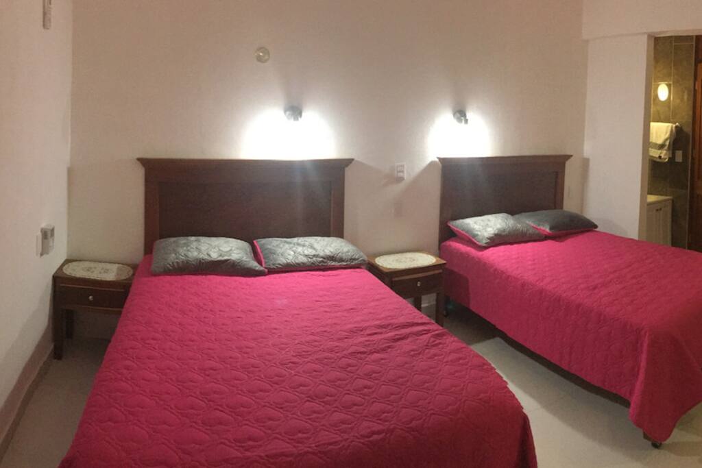 Dos camas matrimoniales en la habitación