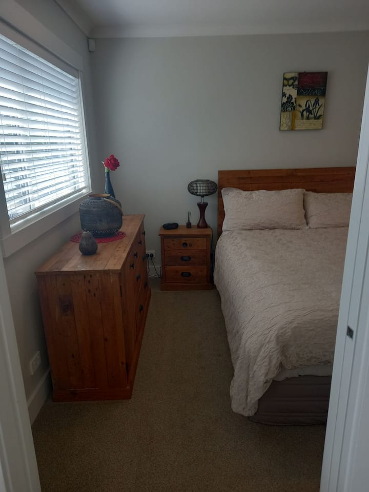 Dormitorio separado con una cama tamaño queen para dos huéspedes 