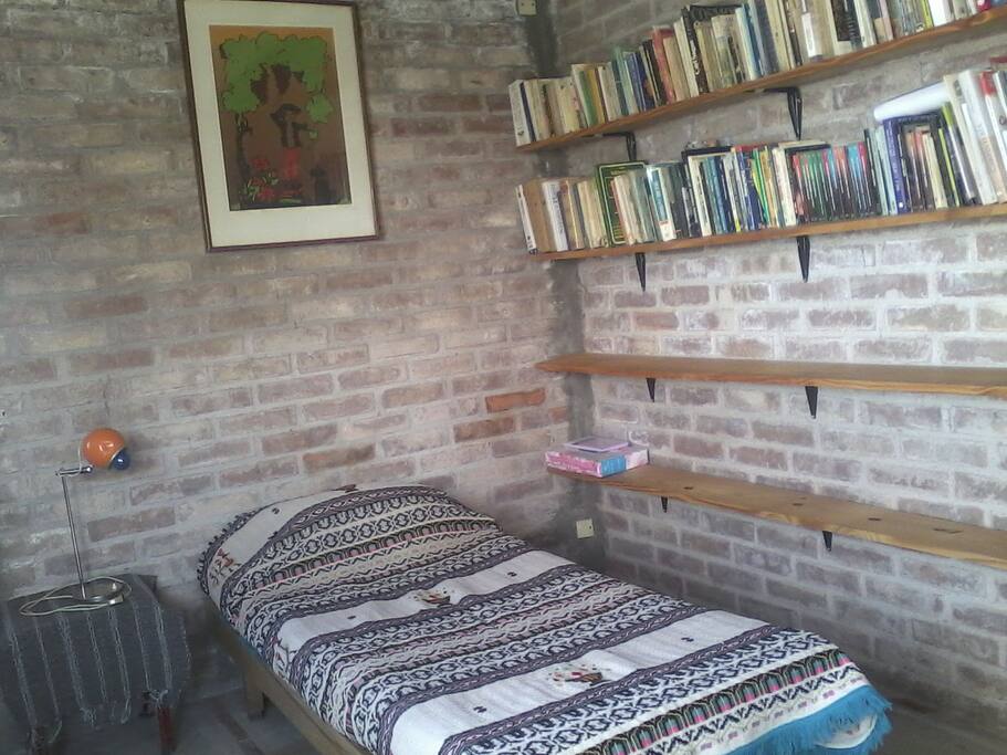 Estantería con libros de interés general y 2 tablones libres a disposición del visitante.