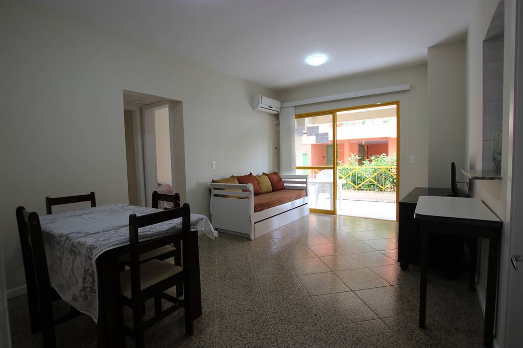 Sala de jantar e estar com saída para a churrasqueira à carvão na sacada.