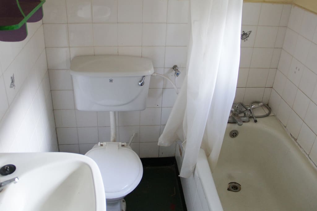 The bathroom has a western toilet, hot water and shower/tub.