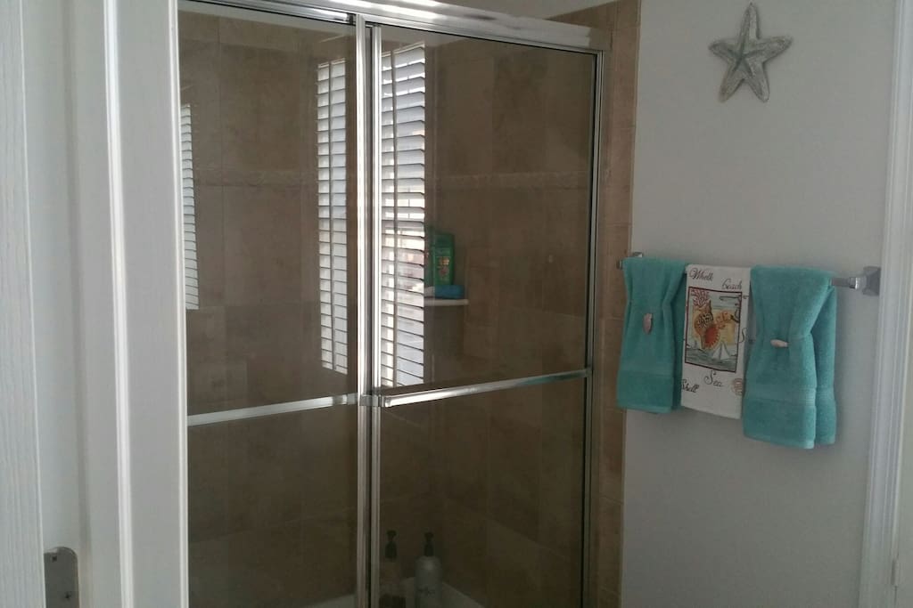 Private bath with ceramic tile shower, vanity and mirror.