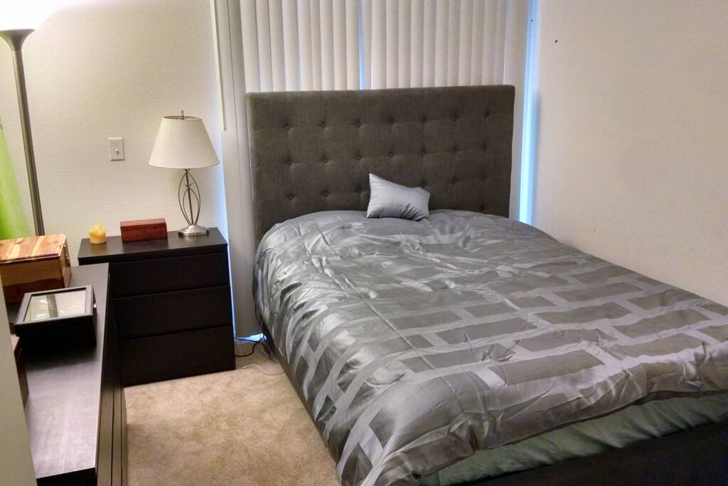 New memory foam mattress and queen bed in cozy room, with view to the balcony.