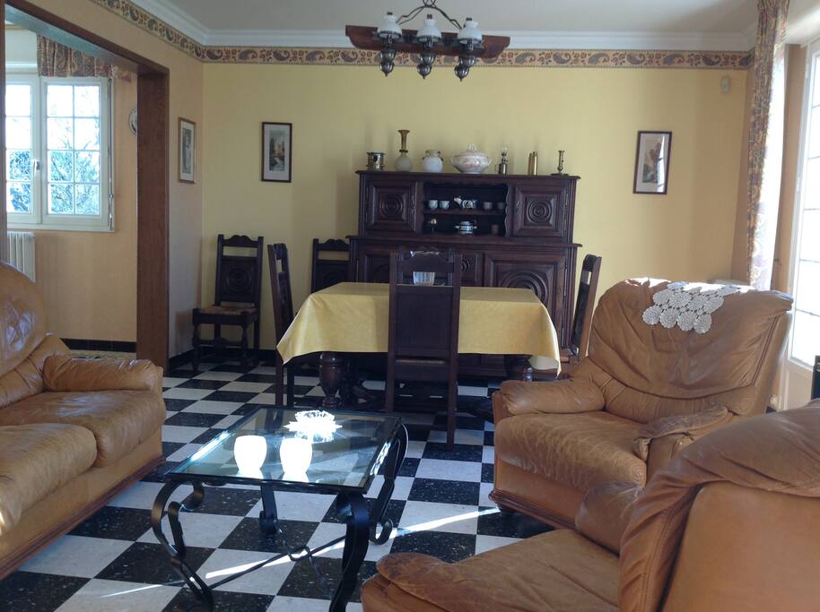 Salon séjour avec 1 canapé, 2 fauteuils et TV, puis un ensemble salle à manger 6/8 personnes