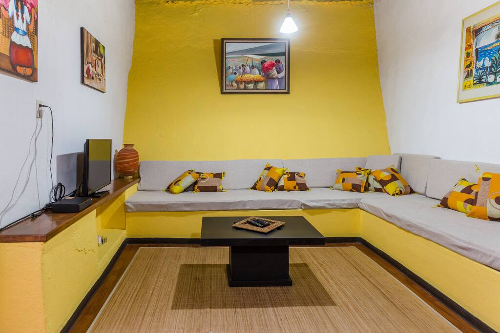 Sala amplia cuyos sofás pueden ser utilizadas como dos camitas individuales