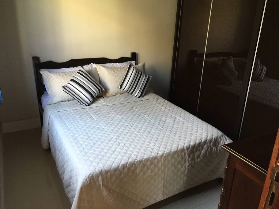 Cama de casal, cômoda e armário.