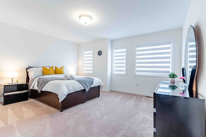 Amplio tercer dormitorio con muchas ventanas y ropa de cama de primera línea con cama tamaño queen