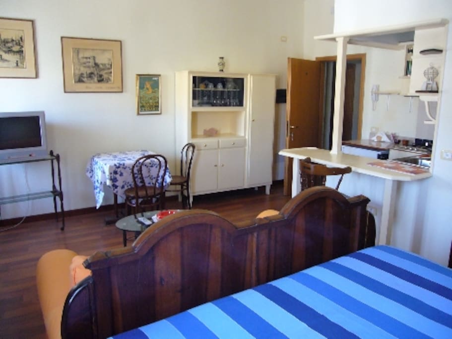 ZONA LIVING CON DIVANO E TV. TAVOLO PER PRANZI O CENETTE.