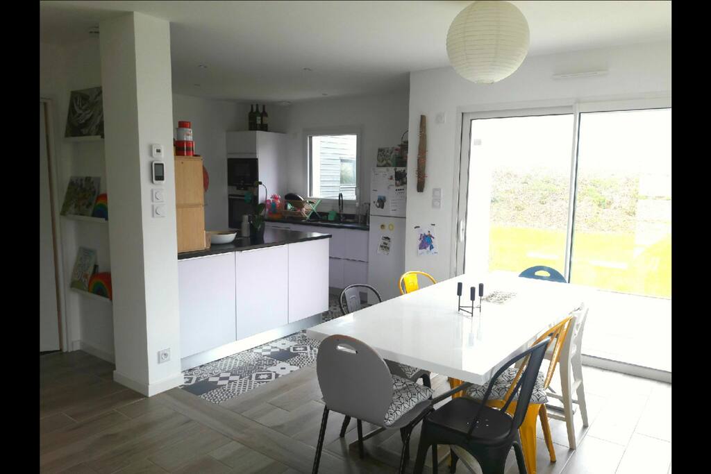 Salle à manger et cuisine, baie vitrée donnant sur la terrasse.