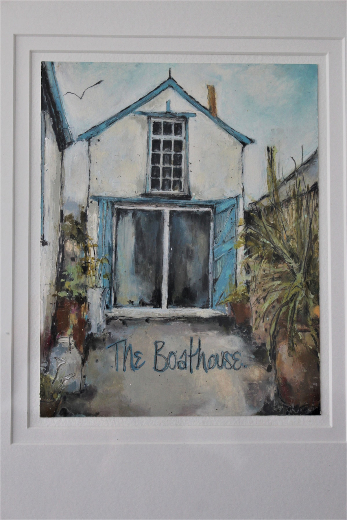 A painted depiction of The Boathouse showcases its charming exterior. Blue shutters frame expansive glass doors, while the surrounding area includes potted plants. The artwork captures the essence of the cabin's quaint character, set against a light blue sky with hints of flying birds.