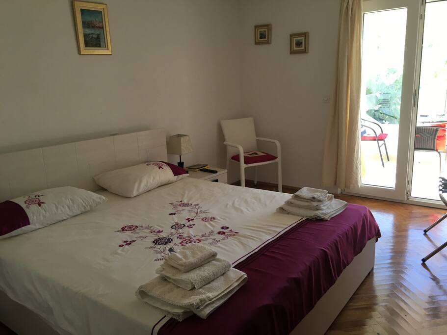 Bright comfortable bedroom with the view of the sea and the mountains