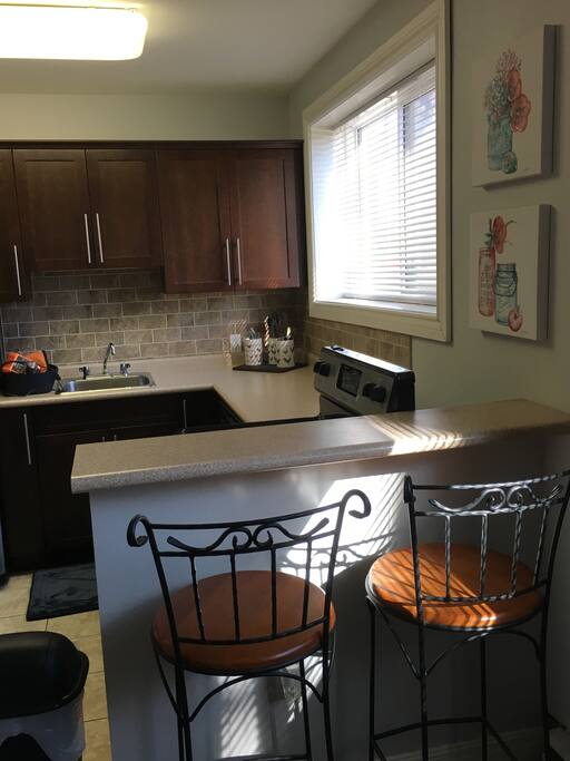 Bright and elegant one bedroom condo. This photo shows the eating bar and some of the kitchen area. Eating bar doubles as one of the condo’s ideal laptop ready workspaces.