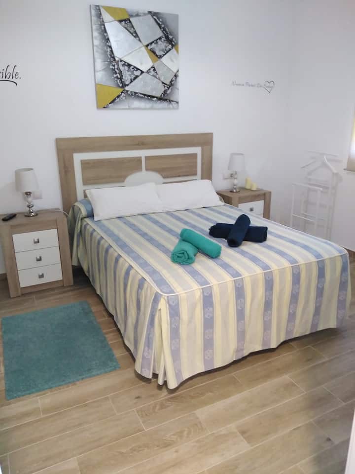 غرفة نوم مزدوجة كبيرة مع تلفزيون وإطلالات على الحديقة