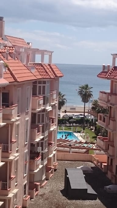 Piso en recinto cerrado con piscina en primera línea de playa. Vistas de la playa y de la piscina desde la terraza del piso.