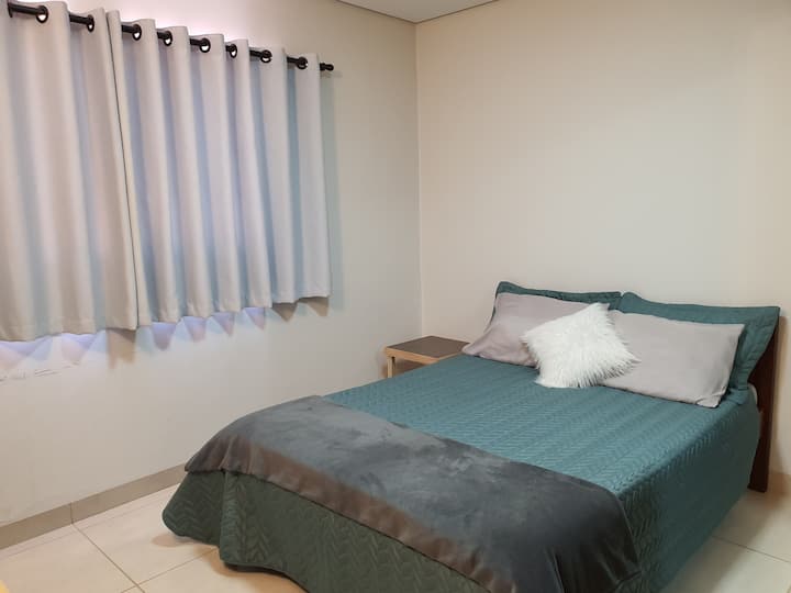 Dormitorio con aire acondicionado y cama con almohadas adicionales.