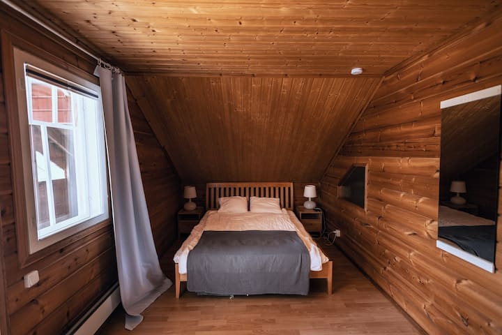 Large bedroom with double bed. Access to balcony with river view.

Nightstands reading lights on both sides.

Darkening curtains help the brightness of the midsummer.